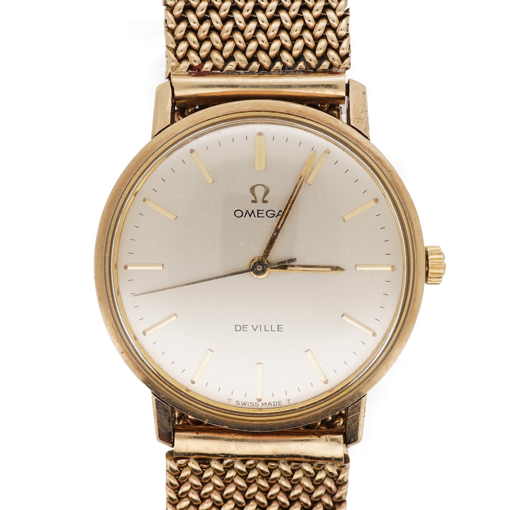 A gentleman's early 1970's 9ct gold Omega De Ville manual wind wrist watch, on an associated 9ct gold mesh link bracelet